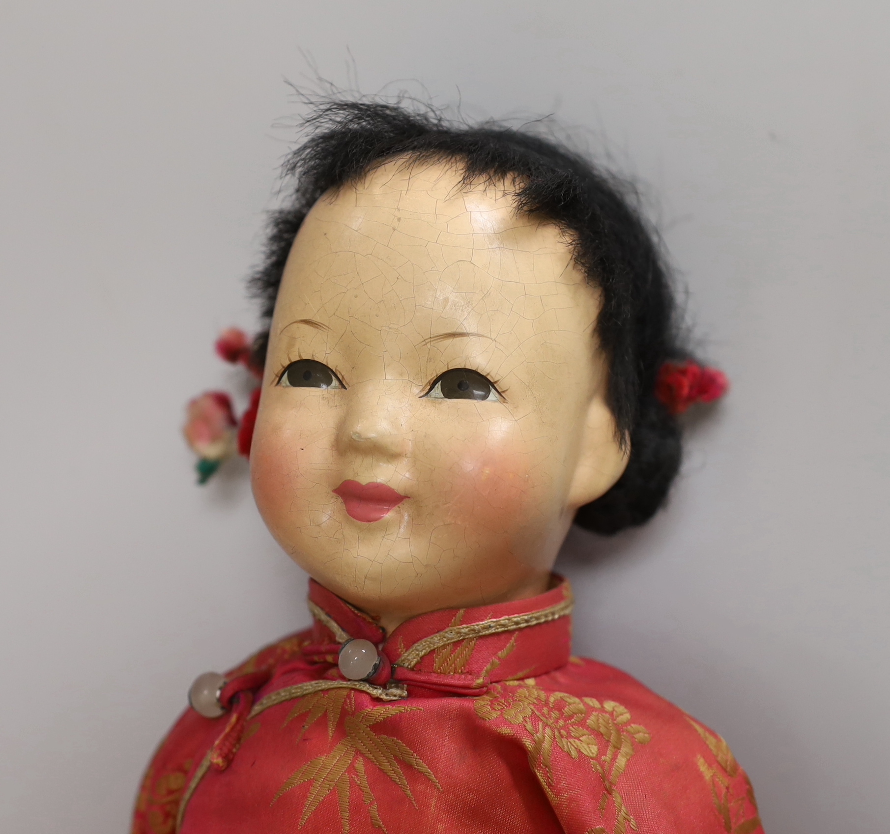 A composition Burmese doll, 40cm, related hat and a shoe